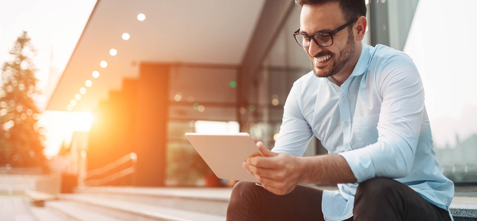 A business man outside his office using a smart tablet